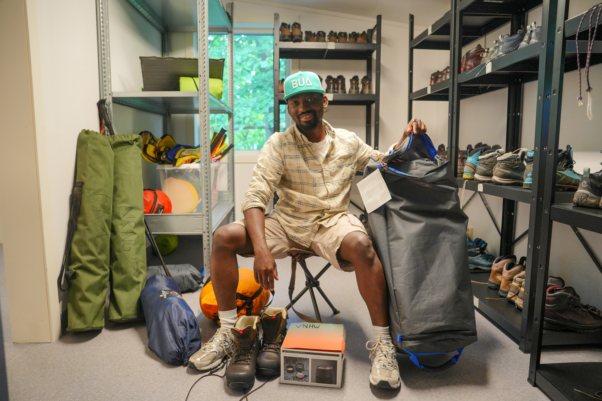 Mufano Rutikanga viser frem en liten del av utstyret du kan låne på BUA. Det er telt, primus, klappstol og sovepose.